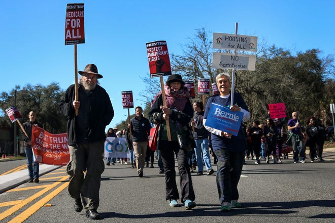 Groups of people walk down University Avenue during the 2020 King celebration in Gainesville Fla. on Jan. 20, 2020. [Sam Thomas/The Gainesville Sun]