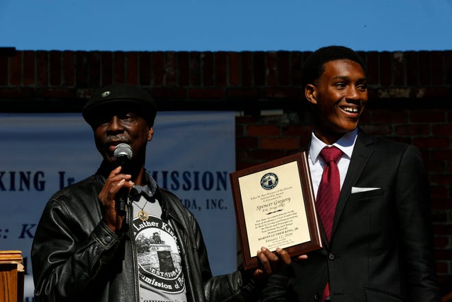Rodney Long presents Spencer Gregory, a senior at P.K. Yonge Developmental Research School, with a plaque for the Edna M. Hart Keeper of the Dream scholarship during the 2020 King Celebration in Gainesville, Fla. on Jan. 20, 2020. The celebration was presented by the Martin Luther King, Jr. Commission of Florida, Inc. [Sam Thomas/The Gainesville Sun]