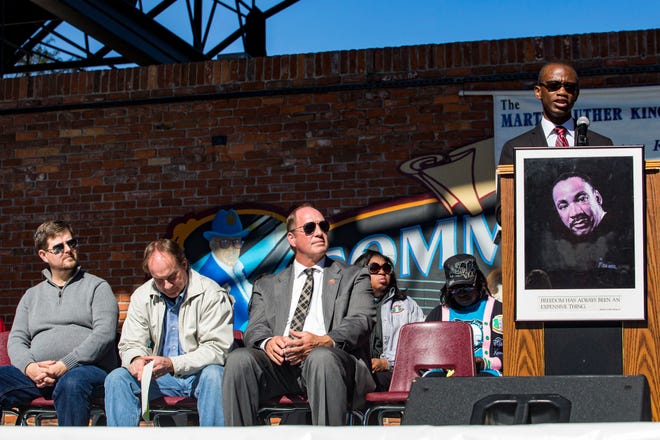 (From left to right) Gainesville Mayor Lauren Poe, Alachua County Commissioner Lee Pinkoson and Congressman Ted YoHo listen to Samuel Ray speak during the Martin Luther King Jr. Commission of Florida's celebration event for MLK at Bo Diddley Downtown Community Plaza on Monday, January 15, 2018. Ray was the 2018 recipient of the Edna M. Hart Keeper of the Dream scholarship award. 

[LAUREN BACHO / STAFF PHOTOGRAPHER]
