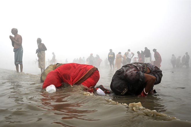 January 15, 2024: Pilgrims take a holy dip amid dense fog at the confluence of River Ganges and the Bay of Bengal during 'Gangasagar Mela' on the occasion of the Hindu festival of Makar Sankranti at Sagar Island, around 150 km south of Kolkata.