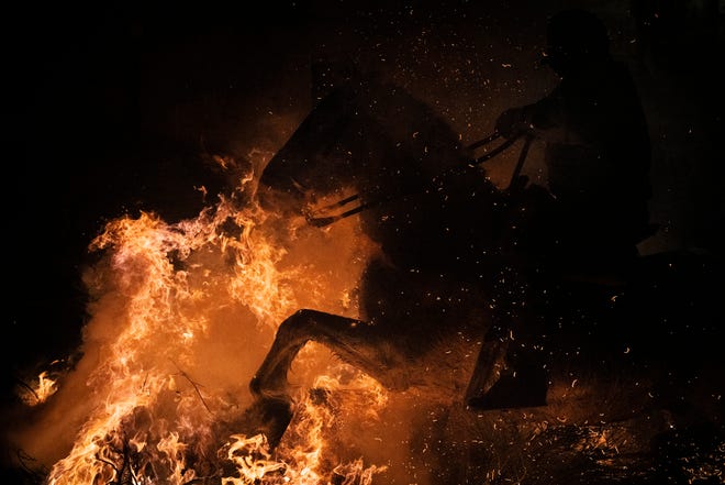 January 16, 2024: A man rides a horse through a bonfire as part of a ritual in honor of Saint Anthony the Abbot, the patron saint of domestic animals, in San Bartolome de Pinares, Spain. On the eve of Saint Anthony's Day, dozens ride their horses through the narrow cobblestone streets of the small village of San Bartolome during the "Luminarias," a tradition that dates back 500 years and is meant to purify the animals with the smoke of the bonfires and protect them for the year to come.