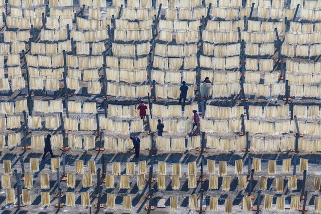 January 25, 2024: Villagers hang noodles out to dry in a field as they prepare for upcoming Lunar New Year markets in Huai'an, in China's eastern Jiangsu province.