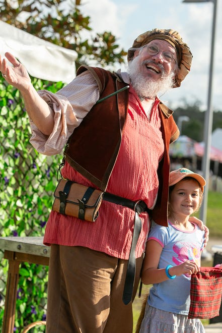 Magician James Songster performs magic with audience member Claire Fonseca, 7, during the annual Hoggetowne Medieval Faire at Depot Park in Gainesville, FL on Saturday, January 27, 2024.