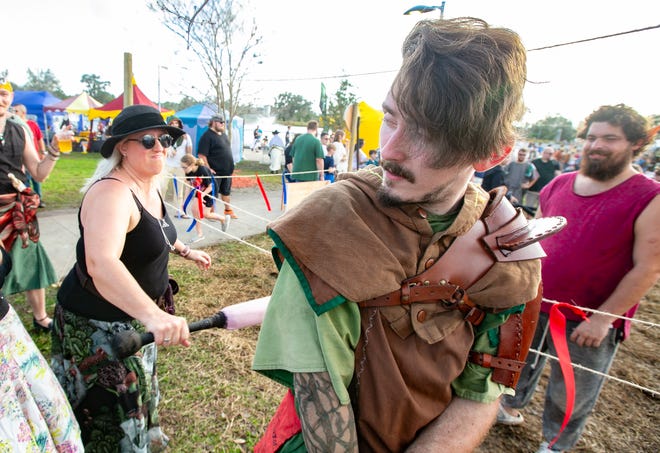Terri Lewis, center, gives Will Greening a whack in the back during the annual Hoggetowne Medieval Faire at Depot Park in Gainesville, FL on Saturday, January 27, 2024.